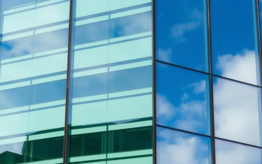 Modern commercial glass facade reflecting blue sky